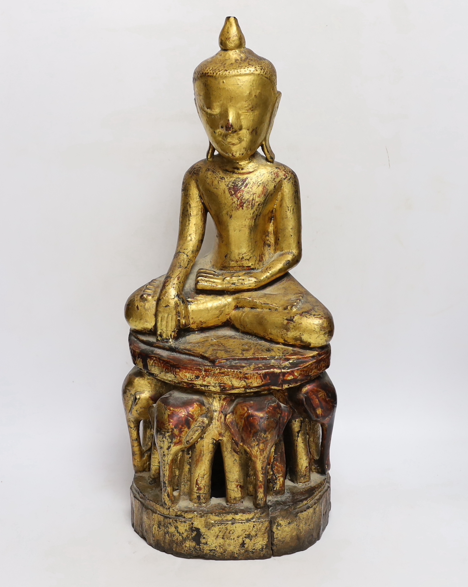 A 19th century Burmese or Thai giltwood figure of Buddha, on an elephant throne, 52cm